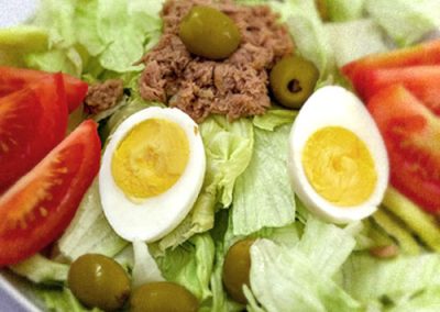 Ensalada de lechuga, tomate, huevo, aceitunas y atún